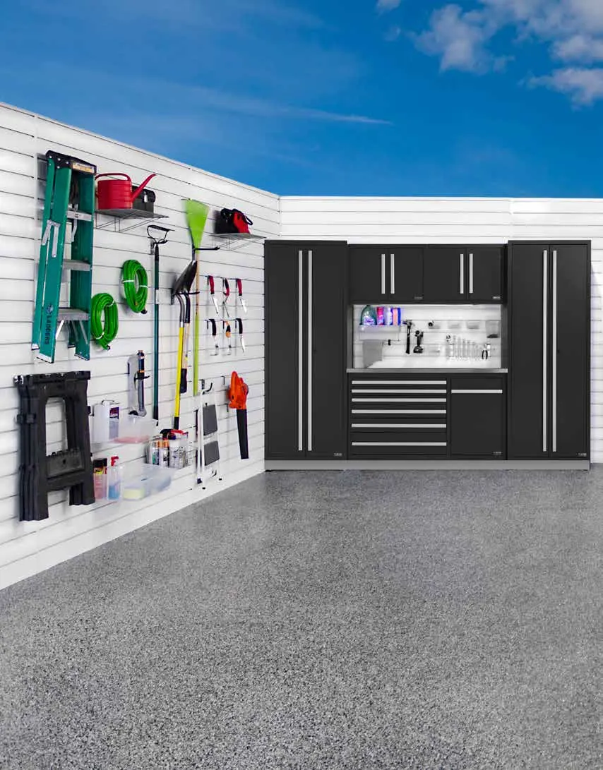 White slatwall with tools beside black cabinets