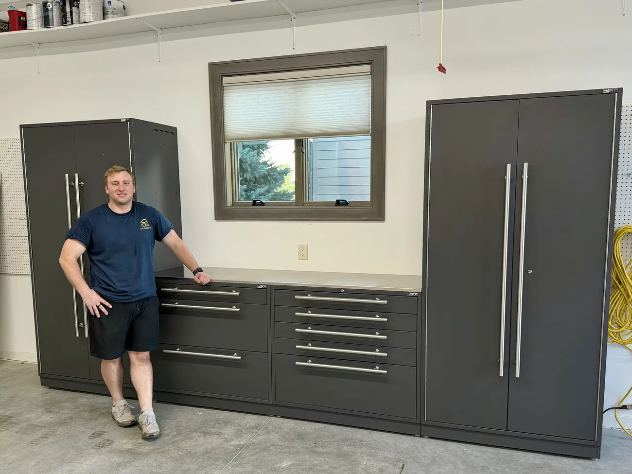 Troy from Top Garage standing in front of a finished Proslat cabinet install